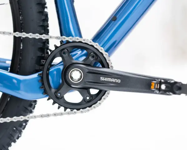 Jak odkręcić pedały w rowerze? Widok na korbę Shimano, łańcuch i fragment ramy roweru.