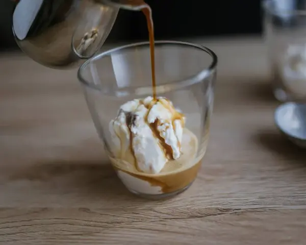 Gorące espresso zalewa gałkę lodów waniliowych, tworząc pyszne affogato.