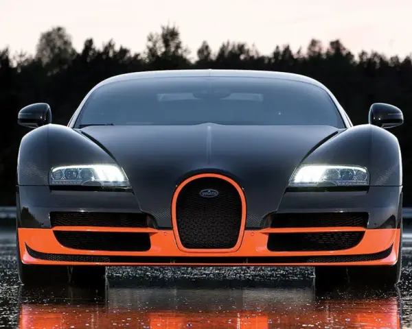 Czarny Bugatti Veyron z pomarańczowymi akcentami, gotowy do jazdy po mokrej nawierzchni.