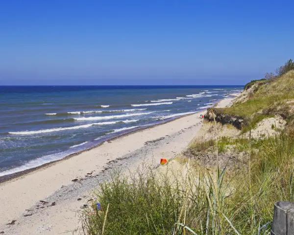 Plaża nad Bałtykiem, fale rozbijają się o brzeg. Czy morze bałtyckie jest słone? Tak, nawet w upalny dzień.