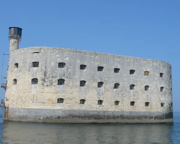 Fort Boyard, imponująca kamienna twierdza na wodzie, z licznymi oknami i wieżą.