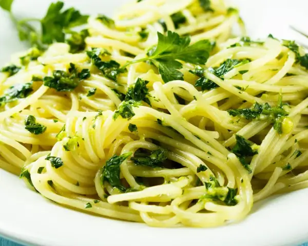 Pyszne spaghetti z zielonym pesto i świeżą natką pietruszki. Idealne na szybki obiad, inspiracja z przepisów z pesto.