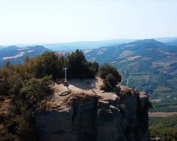 Due escursionisti celebrano la vetta raggiunta sul crinale, un momento clou del cammino della Via degli Dei in 5 giorni.