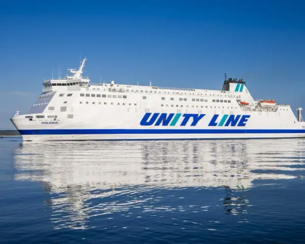 Biały prom Unity Line "Polonia" płynie po spokojnym, błękitnym morzu.