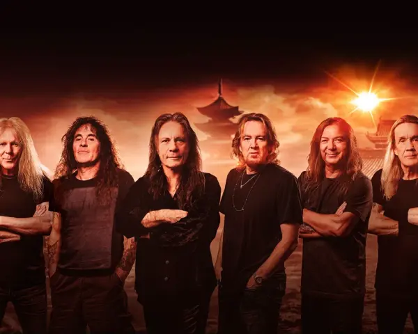 Les membres de Iron Maiden posent devant un paysage asiatique au coucher du soleil.