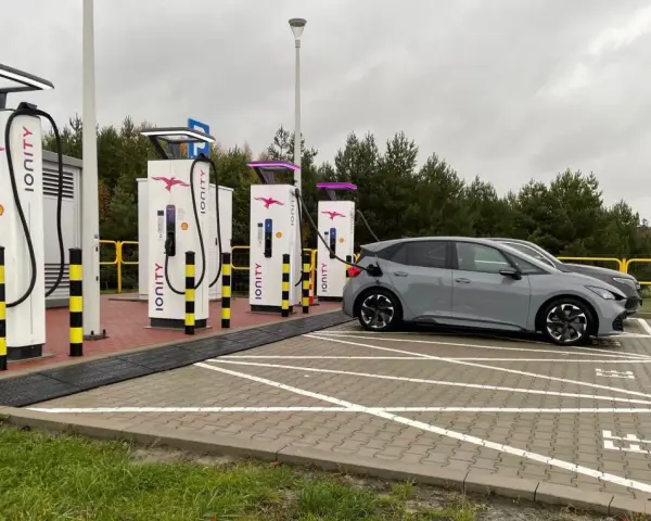Szara Skoda Enyaq ładuje się na stacji Ionity Polska. Obok kolejne ładowarki i samochody elektryczne.