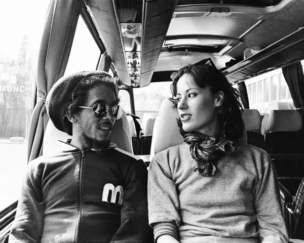 Bob Marley i Kate Marley w autobusie, patrzą na siebie z uśmiechem.