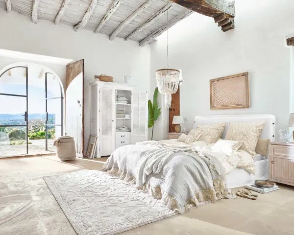 Elegantes dormitorio ideas con cama grande, armario blanco y puertas abiertas a un paisaje soleado.