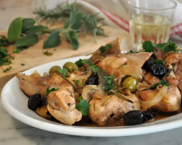 Piatto di coniglio alla cacciatora in bianco, con olive, cipolle e rosmarino. Un classico della cucina italiana.