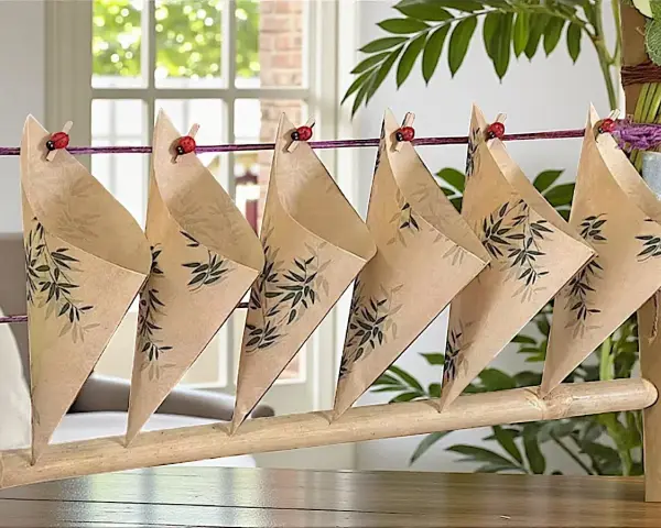 Cucuruchos de papel con diseño de bambú, colgados con pinzas de mariquita. Ideas para hacer cucuruchos de papel.