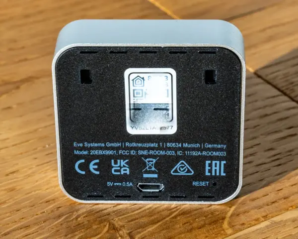 Rückseite eines Eve Systems Geräts mit QR-Code und Reset-Knopf. Modell SNE-ROOM-003.