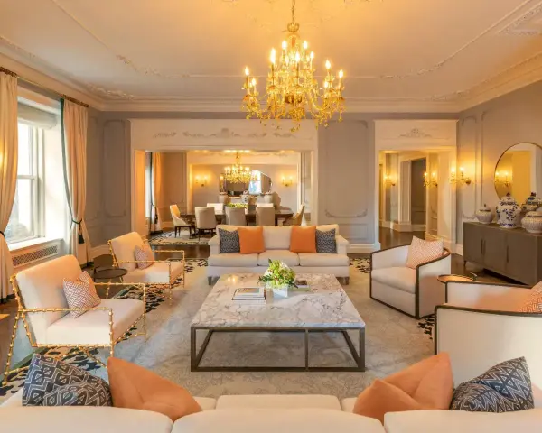 Elegancki salon z marmurowym stolikiem i złotym żyrandolem. Sprawdź hotel Plaza Nowy Jork ceny, by poczuć ten luksus.