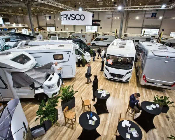 Wielka hala targowa pełna kamperów i przyczep kempingowych. Widać logo ERWIN HYMER GROUP.