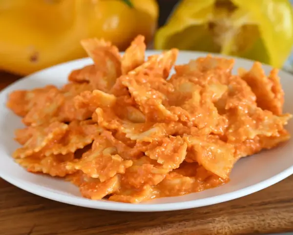 Farfalle condite con una cremosa salsa ai peperoni, un piatto colorato e gustoso.