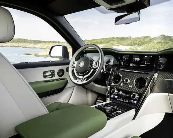Wnętrze luksusowego Rolls-Royce SUV z zielonymi i białymi skórzanymi detalami, widok na morze.