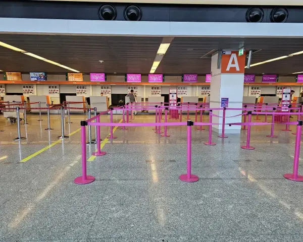 Puste stanowiska Wizzair, gdzie trwa odprawa. Różowe taśmy wyznaczają kolejkę do lotu.