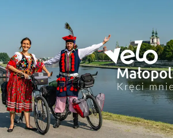 Para w strojach ludowych na rowerach nad Wisłą, promuje Velo Małopolska.