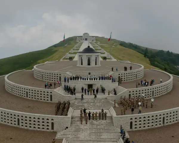 Monumento ai caduti sul Monte Grappa, Prima Guerra Mondiale. Una banda militare suona mentre soldati rendono omaggio.