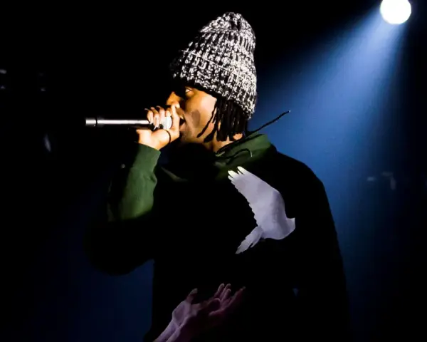 Playboi Carti Polska na scenie, w czapce i bluzie z gołębiem.