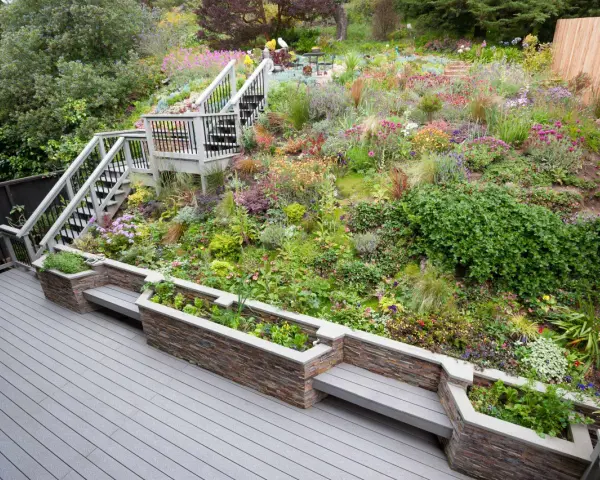Magnifique aménagement talus raide avec escalier, terrasses et jardinières fleuries. Un jardin luxuriant et coloré.