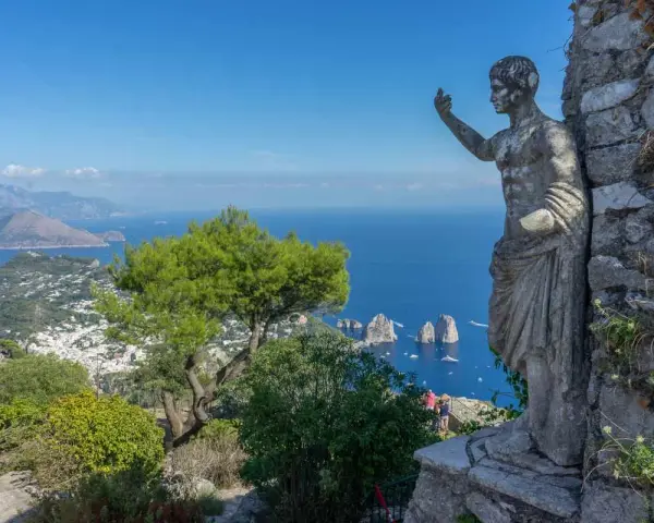 Statua antica domina il panorama mozzafiato di Capri. Un invito a scoprire cosa visitare a Capri, tra mare blu e Faraglioni.