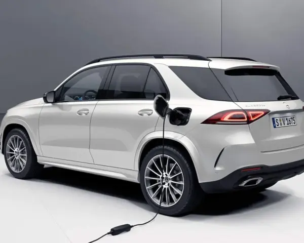 Biały samochód hybrydowy Mercedes-Benz GLE jest ładowany.
