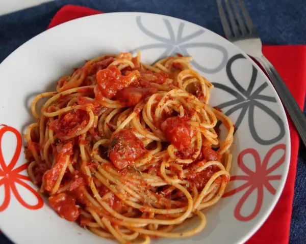 Pyszne spaghetti napoli przepis na talerzu, z sosem pomidorowym i ziołami. Idealne danie dla miłośników włoskiej kuchni.