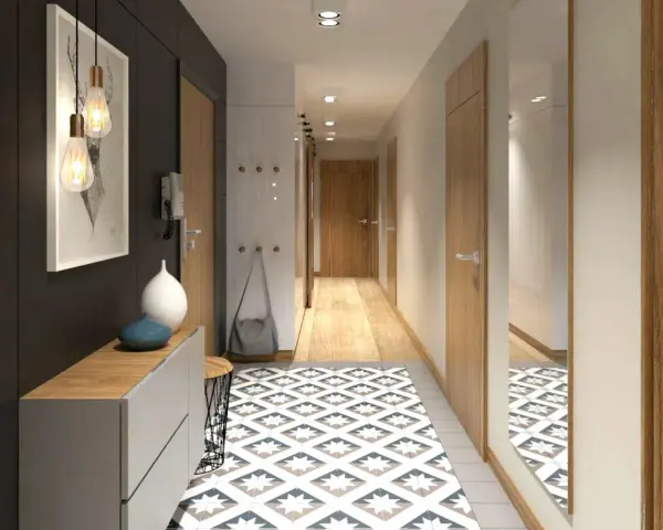 Un corridoio stretto con un tappeto geometrico, mobili moderni e un quadro astratto. Idee per un corridoio che unisce funzionalità ed estetica.