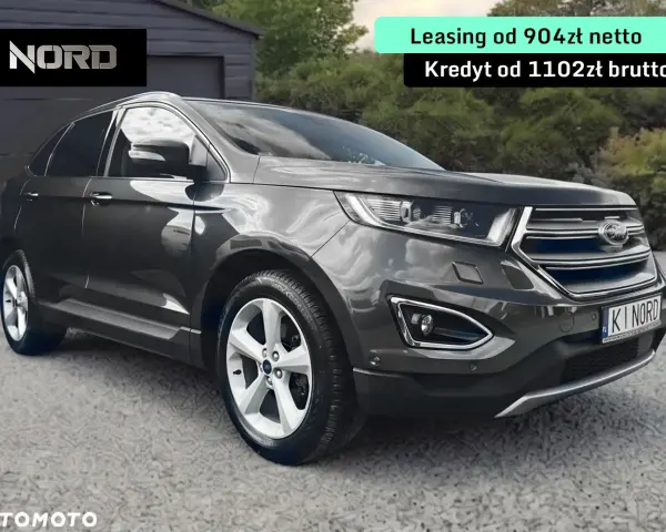 Ford Edge 2.0 TDCI w ciemnoszarym kolorze, zaparkowany przed garażem. Oferta leasingu i kredytu.