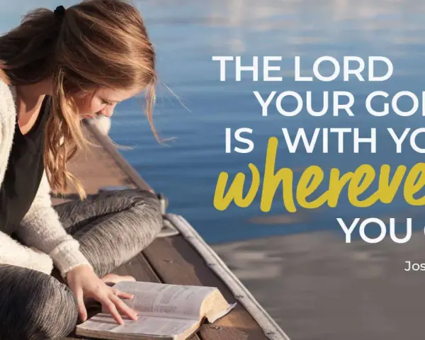 A young woman reads her Bible by the water, finding comfort in trusting God in difficult times with verses like Joshua 1:9.