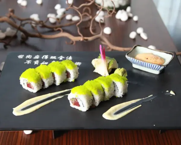 Sushi z zielonym ikrą, podane z delikatnym sosem wasabi i marynowanym imbirem.