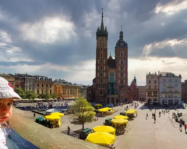 Małe dziecko w czapce patrzy na Rynek Główny w Krakowie, gdzie znajdują się liczne atrakcje dla dzieci w krakowie, w tym kramy z żółtymi parasolami.