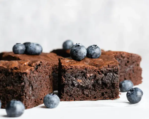 Keto brownie z mascarpone, udekorowane świeżymi borówkami. Idealne na deser bez wyrzutów sumienia.