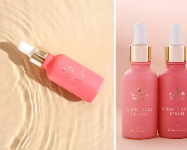 Różowe serum Annabelle Minerals z niacynamidem na trądzik. Dwa flakoniki z pipetką, jeden w wodzie, drugi obok.