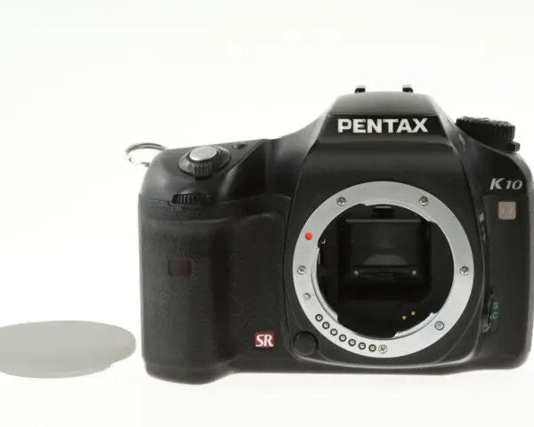 Czarny aparat Pentax K10 z widocznym mocowaniem obiektywu i osłoną. Wewnątrz widoczny jest sensor ccd.