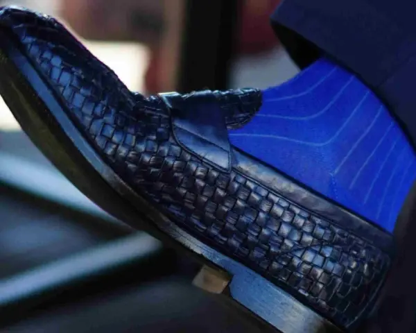 Scarpe blu intrecciate con calzini blu a righe: un abbinamento elegante per un look sofisticato.