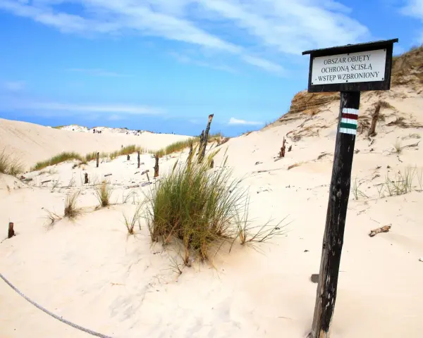 Plaża z wydmami i znakiem "Obszar objęty ścisłą ochroną". Może to miejsce, gdzie kręcono Seks-misję, z charakterystycznymi, surowymi krajobrazami.
