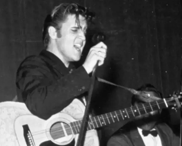 Elvis Presley singt mit Leidenschaft und spielt Gitarre. Ein historischer Moment, vielleicht sein erster Song.
