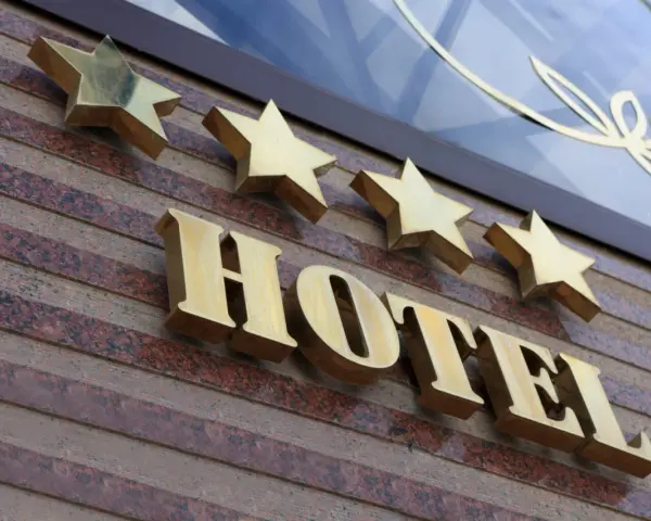 Złote gwiazdki nad napisem HOTEL. To one decydują, kto nadaje gwiazdki hotelom, wskazując na jego standard.