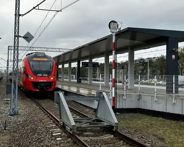 Czerwony pociąg SKM na peronie dworca kolejowego.