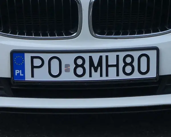Białe auto z polską eku rejestracja PO 8MH80.