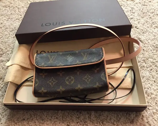 Mała torebka Louis Vuitton w brązowym monogramie, w pudełku z logo marki.