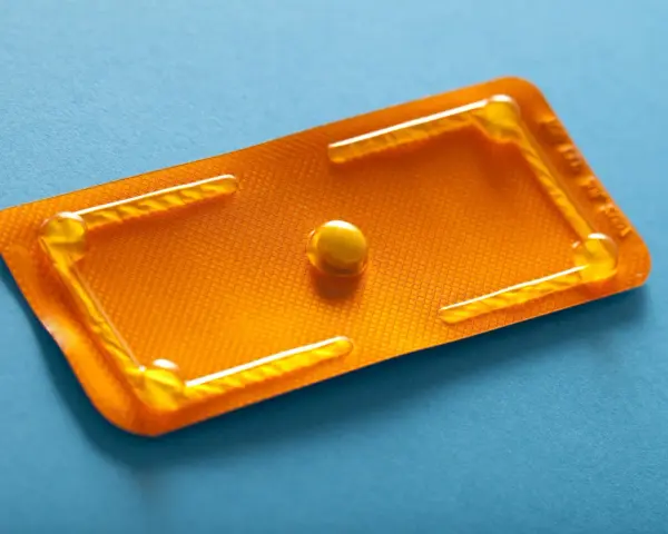 Pillola del giorno dopo, confezione arancione con una singola pillola. Un promemoria visivo di scelte importanti.