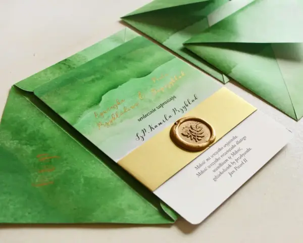Zielone zaproszenia z akwarelowymi wzorami i złotym lakowym stemplem. Czy warto inwestować w personalizowaną papeterię rzemieślniczą z lakiem? Tak!