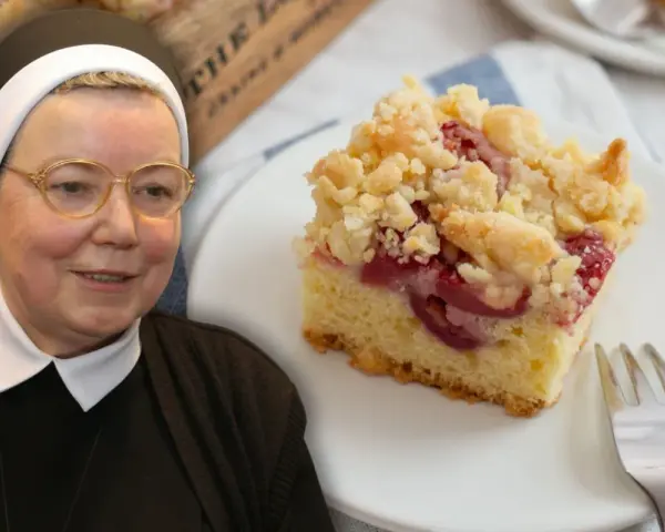 Siostra z uśmiechem prezentuje wilgotne ciasto ucierane ze śliwkami, posypane kruszonką.