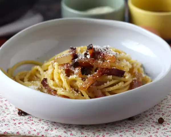 Spaghetti cremosi con guanciale croccante e pecorino, un'autentica ricetta della carbonara.