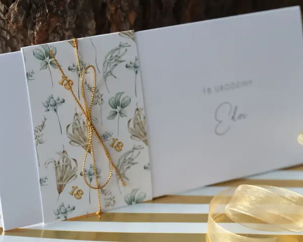 Eleganckie zaproszenia na 18 urodziny z motywem roślinnym i złotym sznurkiem. Idealne, by pokazać, jak spersonalizować zaproszenia na osiemnastkę diy pomysły i materiały.