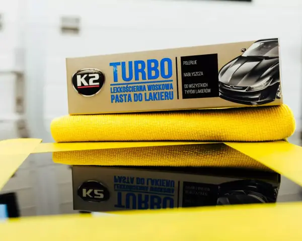 Pudełko pasty do polerowania K2 Turbo i żółta ściereczka z mikrofibry.