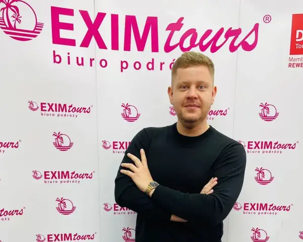Mężczyzna na tle logo EXIM tours. Czy to zapowiedź bankructwa?