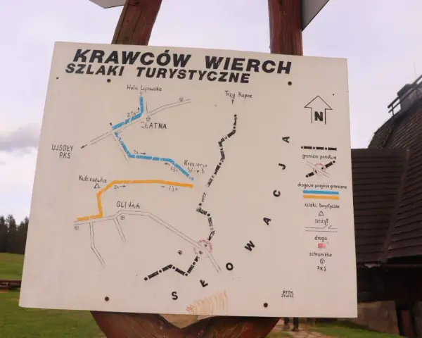 Mapa szlaków turystycznych na Krawców Wierch. Widać szlaki niebieskie, żółte i czarne, punkty PKS, schroniska i przejścia graniczne.